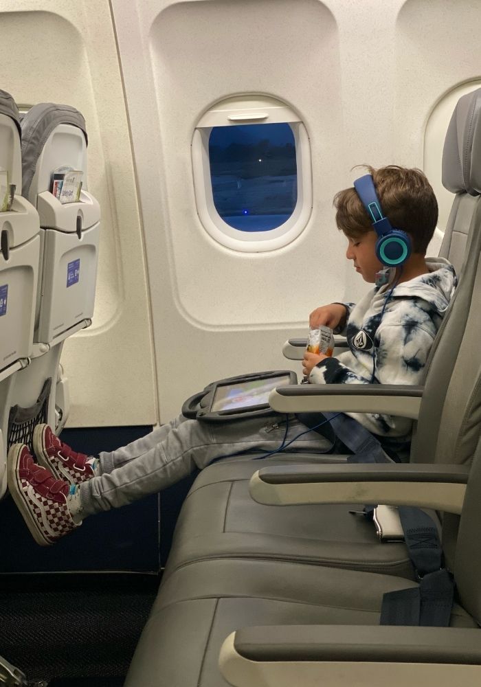 big kid on plane listening to podcast