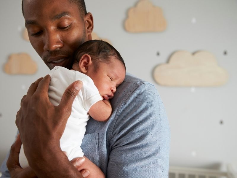 dad helping with newborn baby