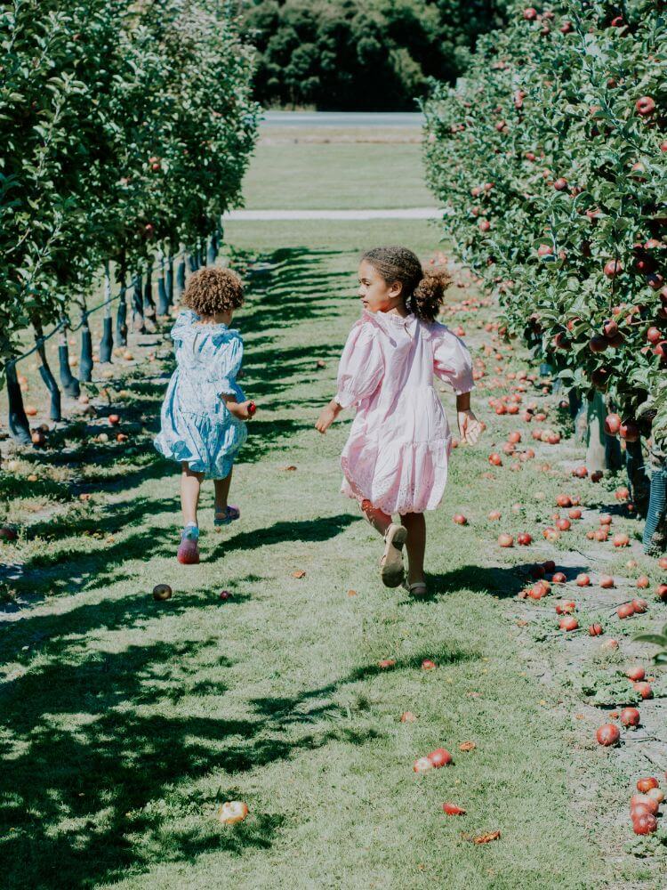 sisters running at apple orchard fall bucket list family activities