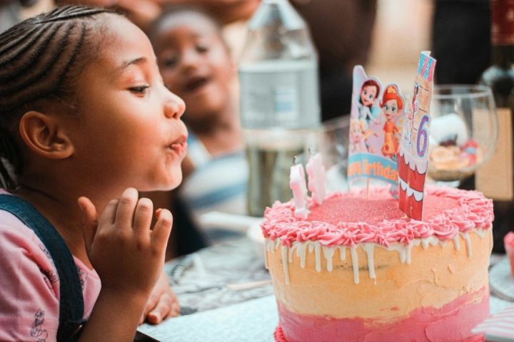 girl blowing out a candle at birthday party