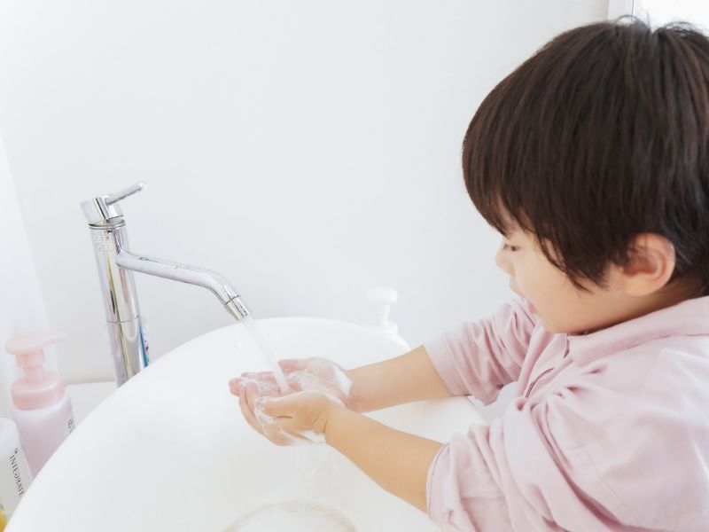 child washing hands to prevent cold flu or covid