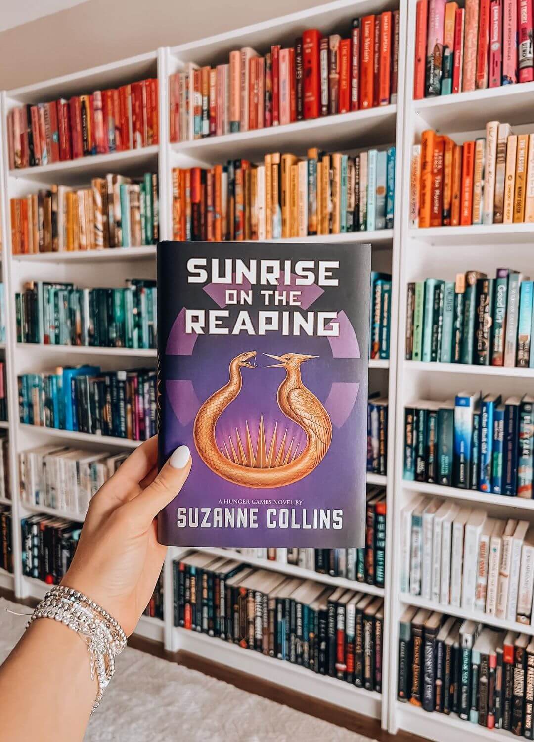 sunrise on the reaping against bookshelf book to movie adaptations