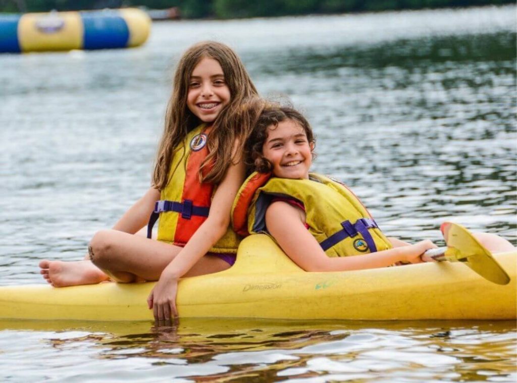 girls on canoe at sleepaway camp
