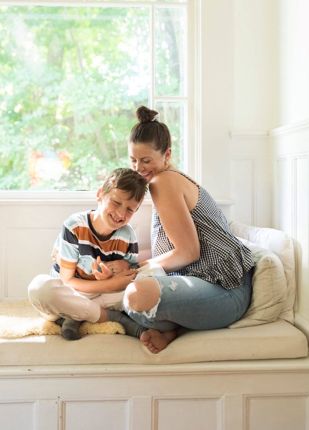 mom and son sitting on window bench