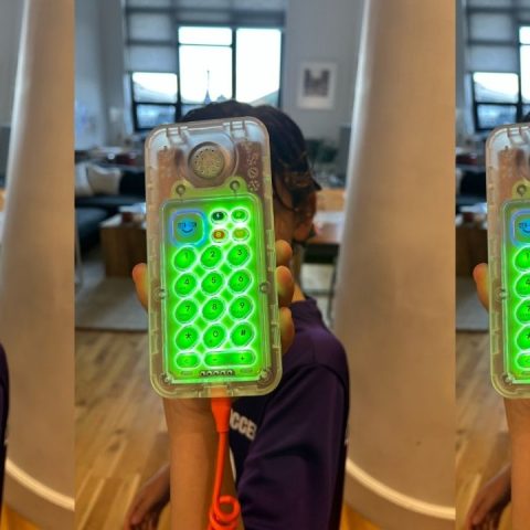 tin can phone review 2026, Child holding the new clear Tin Can phone