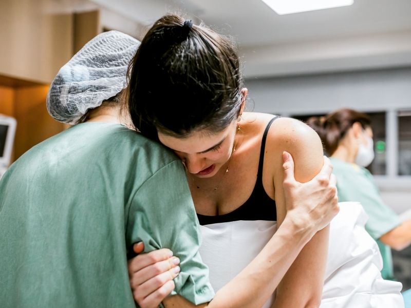 Doula helping pregnant woman during labor